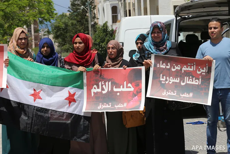 Palestinians hold placards during a rally against Syrian government shelling on the northern city of Aleppo, in front of the headquarter United Nation "UNSCO" in Gaza City, on May 2, 2016. Photo by Mohammed Asad