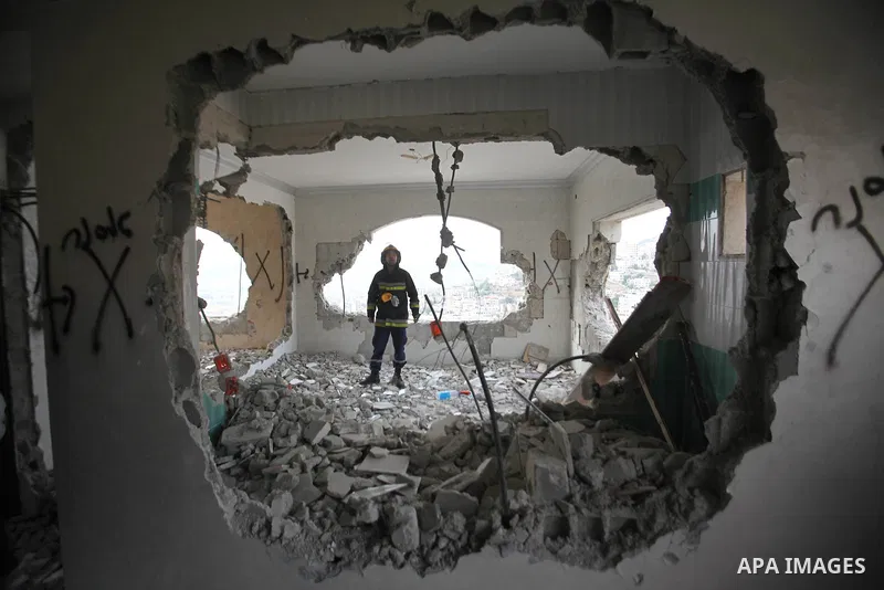 Palestinians look at the damage in the West Bank city of Nablus on May 3, 2016, after Israeli forces destroyed the house of Zaid Amer, a Palestinian man accused of taking part in the killing of a Jewish settler couple ne...