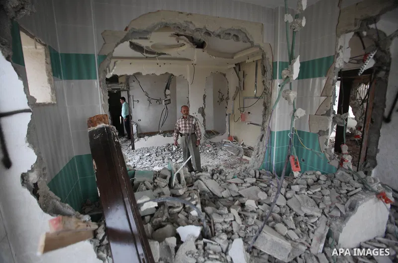 Palestinians look at the damage in the West Bank city of Nablus on May 3, 2016, after Israeli forces destroyed the house of Zaid Amer, a Palestinian man accused of taking part in the killing of a Jewish settler couple ne...