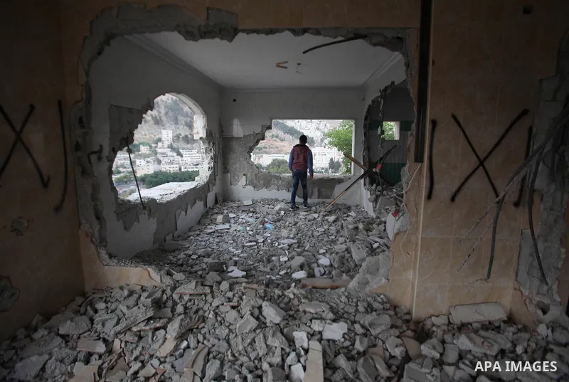 Palestinians look at the damage in the West Bank city of Nablus on May 3, 2016, after Israeli forces destroyed the house of Zaid Amer, a Palestinian man accused of taking part in the killing of a Jewish settler couple ne...