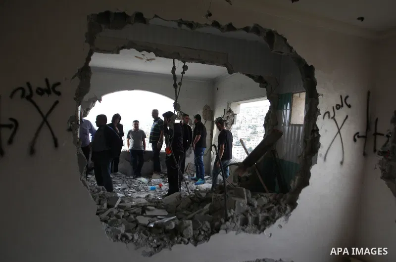 Palestinians look at the damage in the West Bank city of Nablus on May 3, 2016, after Israeli forces destroyed the house of Zaid Amer, a Palestinian man accused of taking part in the killing of a Jewish settler couple ne...