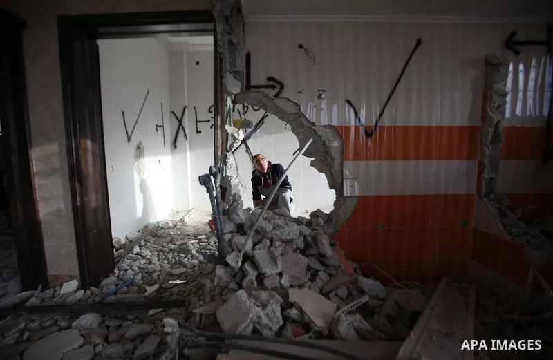 Palestinians look at the damage in the West Bank city of Nablus on May 3, 2016, after Israeli forces destroyed the house of Zaid Amer, a Palestinian man accused of taking part in the killing of a Jewish settler couple ne...