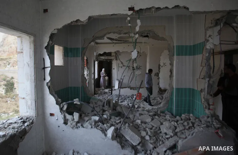 Palestinians look at the damage in the West Bank city of Nablus on May 3, 2016, after Israeli forces destroyed the house of Zaid Amer, a Palestinian man accused of taking part in the killing of a Jewish settler couple ne...