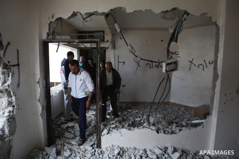 Palestinians look at the damage in the West Bank city of Nablus on May 3, 2016, after Israeli forces destroyed the house of Zaid Amer, a Palestinian man accused of taking part in the killing of a Jewish settler couple ne...