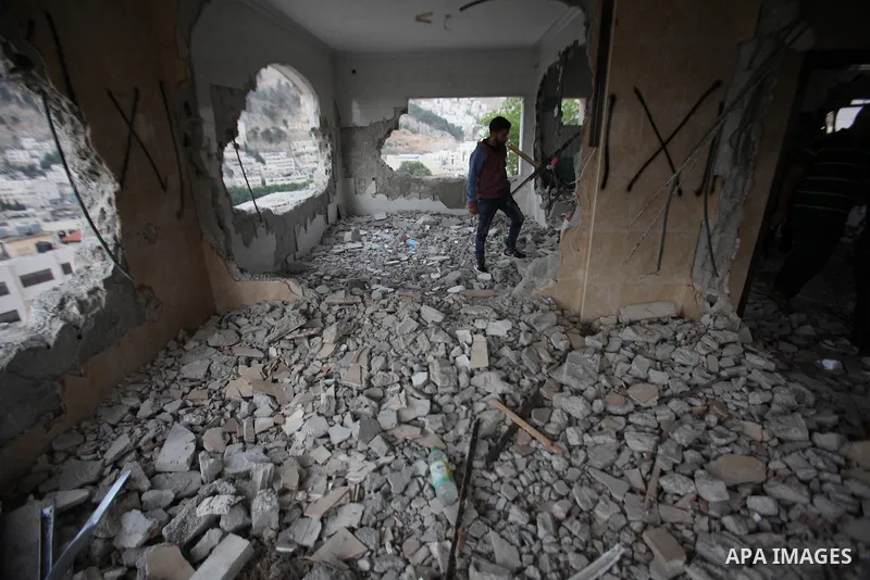 Palestinians look at the damage in the West Bank city of Nablus on May 3, 2016, after Israeli forces destroyed the house of Zaid Amer, a Palestinian man accused of taking part in the killing of a Jewish settler couple ne...