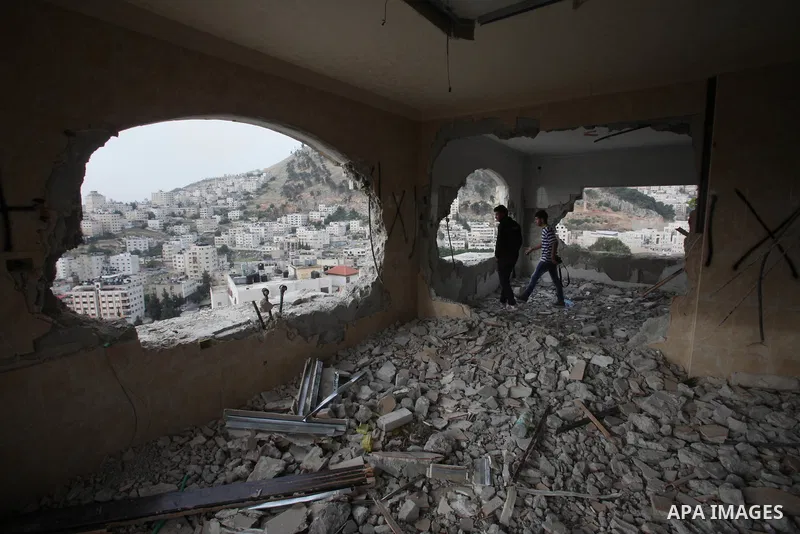Palestinians look at the damage in the West Bank city of Nablus on May 3, 2016, after Israeli forces destroyed the house of Zaid Amer, a Palestinian man accused of taking part in the killing of a Jewish settler couple ne...