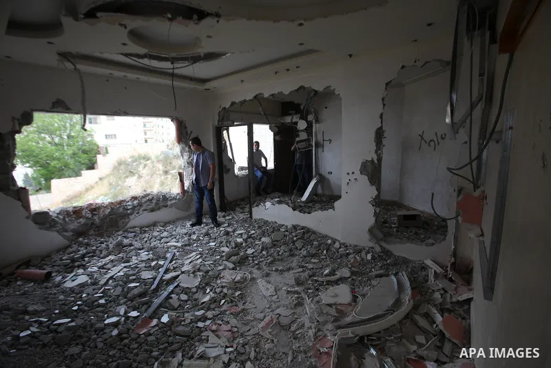 Palestinians look at the damage in the West Bank city of Nablus on May 3, 2016, after Israeli forces destroyed the house of Zaid Amer, a Palestinian man accused of taking part in the killing of a Jewish settler couple ne...