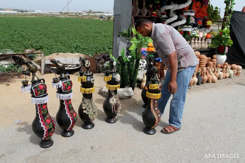A Palestinian man displays handmade vases from pottery, Rafah in the Southern Gaza strip, on May 4, 2016. According to human rights reports, the ongoing Israeli blockade undermines development in all aspects of Palestini...