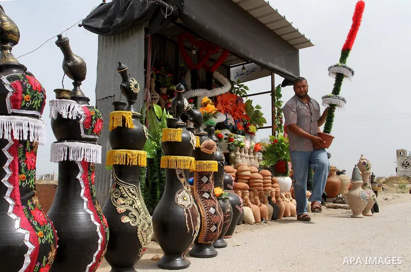 A Palestinian man displays handmade vases from pottery, Rafah in the Southern Gaza strip, on May 4, 2016. According to human rights reports, the ongoing Israeli blockade undermines development in all aspects of Palestini...