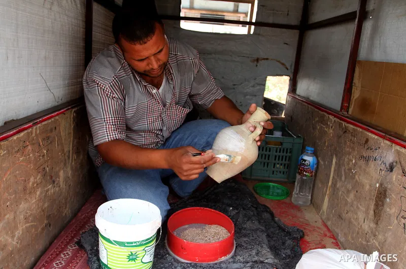 A Palestinian man displays handmade vases from pottery, Rafah in the Southern Gaza strip, on May 4, 2016. According to human rights reports, the ongoing Israeli blockade undermines development in all aspects of Palestini...