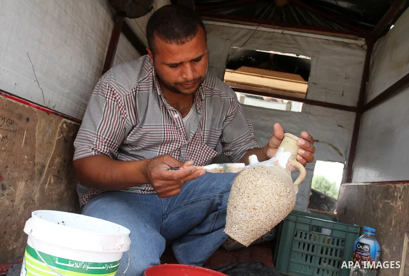 A Palestinian man displays handmade vases from pottery, Rafah in the Southern Gaza strip, on May 4, 2016. According to human rights reports, the ongoing Israeli blockade undermines development in all aspects of Palestini...