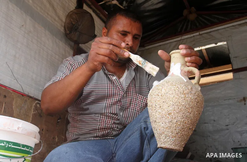 A Palestinian man displays handmade vases from pottery, Rafah in the Southern Gaza strip, on May 4, 2016. According to human rights reports, the ongoing Israeli blockade undermines development in all aspects of Palestini...