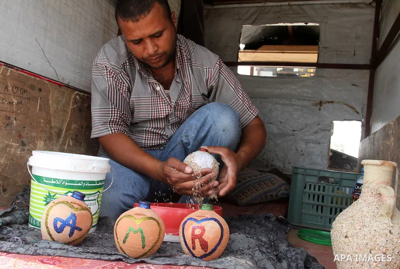 A Palestinian man displays handmade vases from pottery, Rafah in the Southern Gaza strip, on May 4, 2016. According to human rights reports, the ongoing Israeli blockade undermines development in all aspects of Palestini...