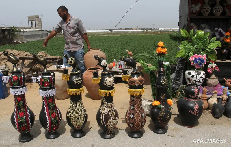 A Palestinian man displays handmade vases from pottery, Rafah in the Southern Gaza strip, on May 4, 2016. According to human rights reports, the ongoing Israeli blockade undermines development in all aspects of Palestini...