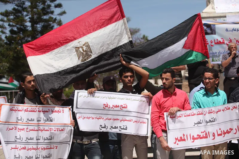 Palestinians hold banners during a protest demanding the Egyptian authorities for the opening of the Rafah crossing, in Gaza, on May 4, 2016. Photo by Ashraf Amra
