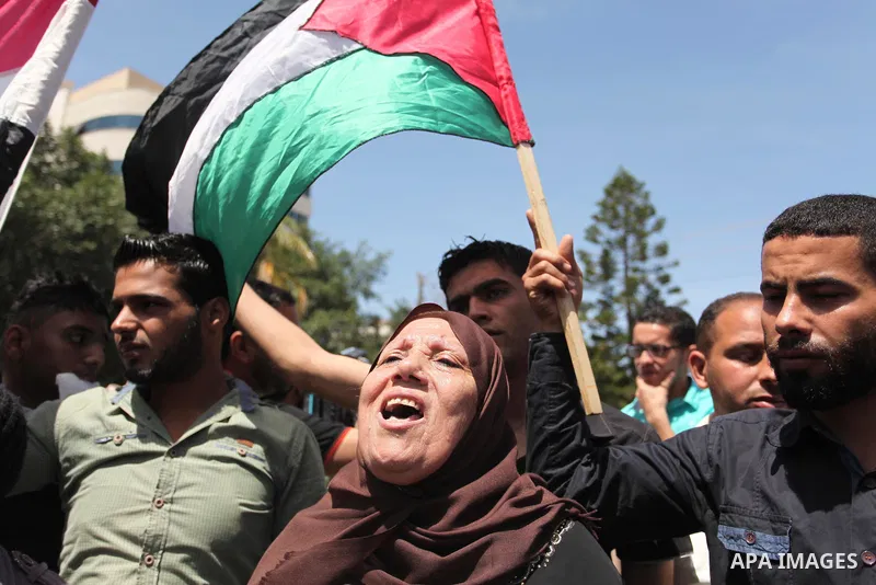 Palestinians hold banners during a protest demanding the Egyptian authorities for the opening of the Rafah crossing, in Gaza, on May 4, 2016. Photo by Ashraf Amra