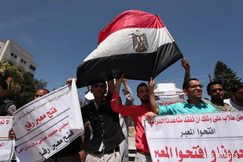 Palestinians hold banners during a protest demanding the Egyptian authorities for the opening of the Rafah crossing, in Gaza, on May 4, 2016. Photo by Ashraf Amra