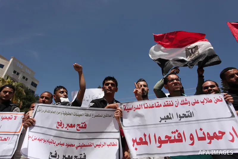 Palestinians hold banners during a protest demanding the Egyptian authorities for the opening of the Rafah crossing, in Gaza, on May 4, 2016. Photo by Ashraf Amra