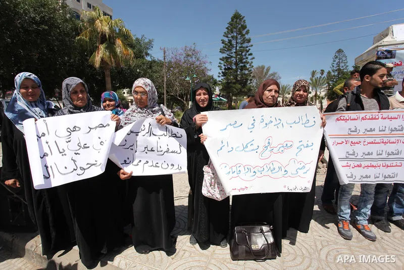Palestinians hold banners during a protest demanding the Egyptian authorities for the opening of the Rafah crossing, in Gaza, on May 4, 2016. Photo by Ashraf Amra