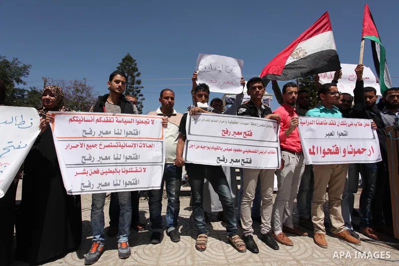 Palestinians hold banners during a protest demanding the Egyptian authorities for the opening of the Rafah crossing, in Gaza, on May 4, 2016. Photo by Ashraf Amra