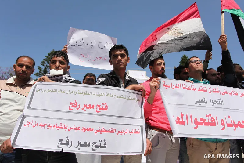 Palestinians hold banners during a protest demanding the Egyptian authorities for the opening of the Rafah crossing, in Gaza, on May 4, 2016. Photo by Ashraf Amra