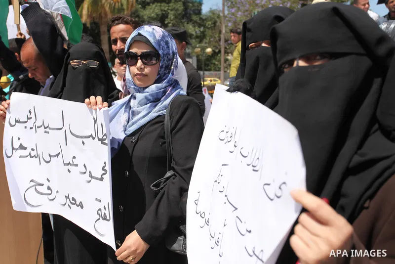 Palestinians hold banners during a protest demanding the Egyptian authorities for the opening of the Rafah crossing, in Gaza, on May 4, 2016. Photo by Ashraf Amra