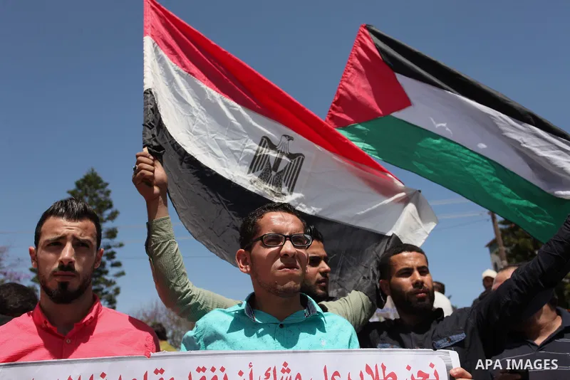 Palestinians hold banners during a protest demanding the Egyptian authorities for the opening of the Rafah crossing, in Gaza, on May 4, 2016. Photo by Ashraf Amra
