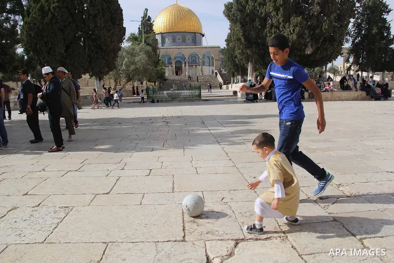 Palestinian boys play football in front of Dome of the Rock mosque at the Al-Aqsa mosque compound in Jerusalem's Old city on May 4, 2016. Photo by Mahfouz Abu Turk