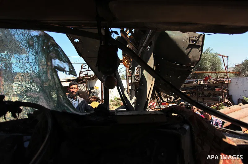 A Palestinian man inspects a damaged vehicle at his workshop after it was hit by an Israeli air strike in Gaza City, in the early hours of May 5, 2016. Israeli air strikes hit four Hamas sites in Gaza overnight, the mili...