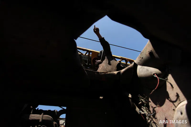 A Palestinian man inspects a damaged vehicle at his workshop after it was hit by an Israeli air strike in Gaza City, in the early hours of May 5, 2016. Israeli air strikes hit four Hamas sites in Gaza overnight, the mili...