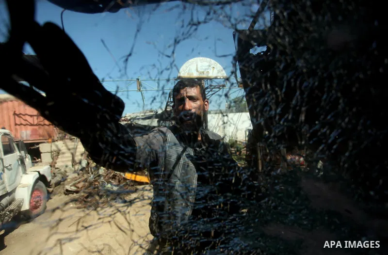 A Palestinian man inspects a damaged vehicle at his workshop after it was hit by an Israeli air strike in Gaza City, in the early hours of May 5, 2016. Israeli air strikes hit four Hamas sites in Gaza overnight, the mili...