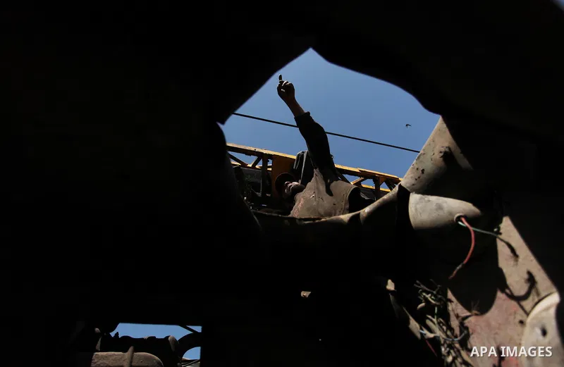 A Palestinian man inspects a damaged vehicle at his workshop after it was hit by an Israeli air strike in Gaza City, in the early hours of May 5, 2016. Israeli air strikes hit four Hamas sites in Gaza overnight, the mili...