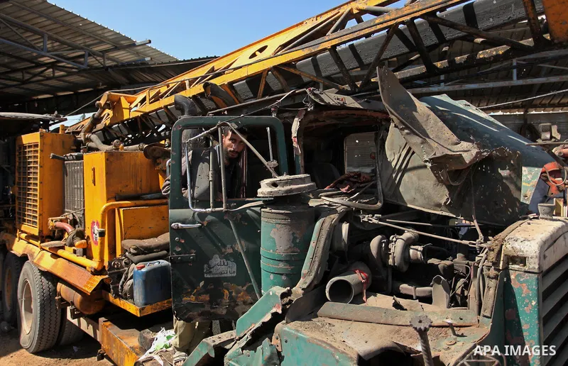 A Palestinian man inspects a damaged vehicle at his workshop after it was hit by an Israeli air strike in Gaza City, in the early hours of May 5, 2016. Israeli air strikes hit four Hamas sites in Gaza overnight, the mili...