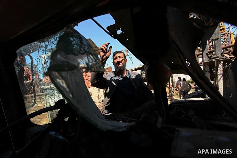 A Palestinian man inspects a damaged vehicle at his workshop after it was hit by an Israeli air strike in Gaza City, in the early hours of May 5, 2016. Israeli air strikes hit four Hamas sites in Gaza overnight, the mili...