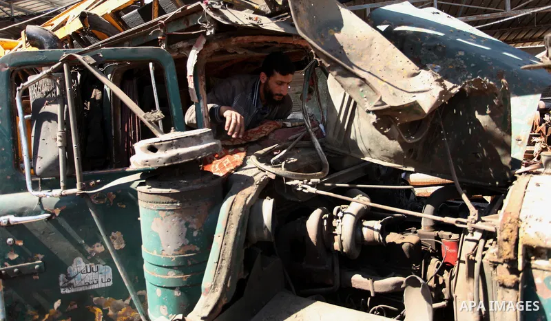 A Palestinian man inspects a damaged vehicle at his workshop after it was hit by an Israeli air strike in Gaza City, in the early hours of May 5, 2016. Israeli air strikes hit four Hamas sites in Gaza overnight, the mili...