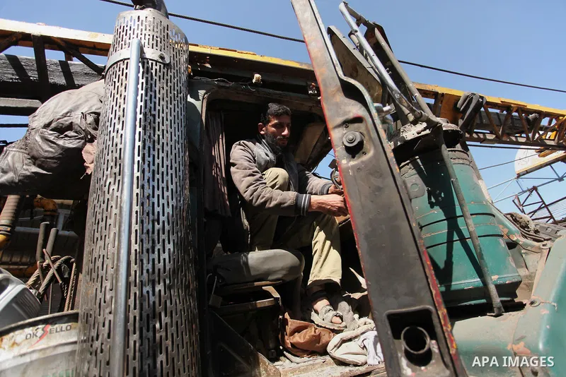A Palestinian man inspects a damaged vehicle at his workshop after it was hit by an Israeli air strike in Gaza City, in the early hours of May 5, 2016. Israeli air strikes hit four Hamas sites in Gaza overnight, the mili...