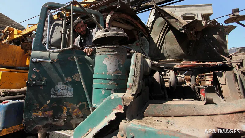 A Palestinian man inspects a damaged vehicle at his workshop after it was hit by an Israeli air strike in Gaza City, in the early hours of May 5, 2016. Israeli air strikes hit four Hamas sites in Gaza overnight, the mili...