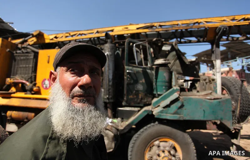 A Palestinian man inspects a damaged vehicle at his workshop after it was hit by an Israeli air strike in Gaza City, in the early hours of May 5, 2016. Israeli air strikes hit four Hamas sites in Gaza overnight, the mili...