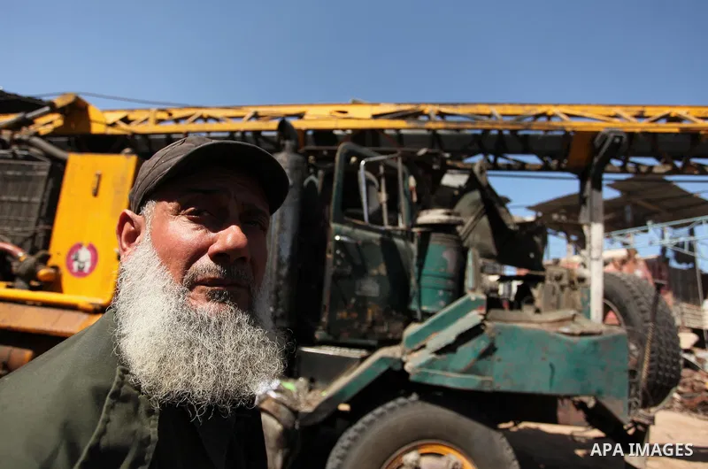 A Palestinian man inspects a damaged vehicle at his workshop after it was hit by an Israeli air strike in Gaza City, in the early hours of May 5, 2016. Israeli air strikes hit four Hamas sites in Gaza overnight, the mili...