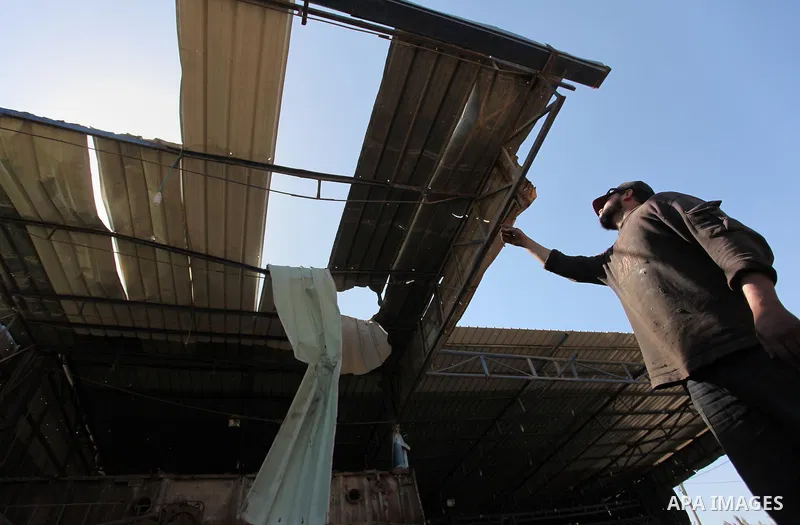 A Palestinian man inspects the scene of what witnesses said was an air strike on a workshop in Gaza City, in the early hours of May 5, 2016. Israeli air strikes hit four Hamas sites in Gaza overnight, the military said,...
