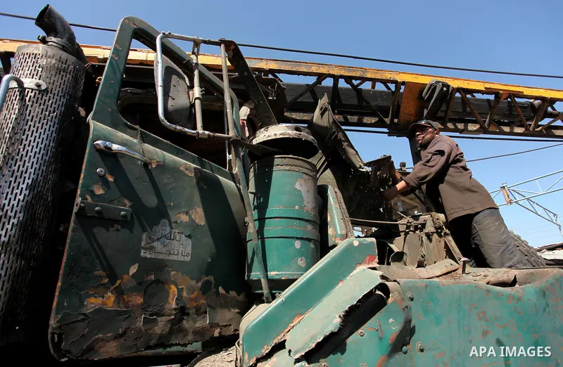 A Palestinian man inspects a damaged vehicle at his workshop after it was hit by an Israeli air strike in Gaza City, in the early hours of May 5, 2016. Israeli air strikes hit four Hamas sites in Gaza overnight, the mili...