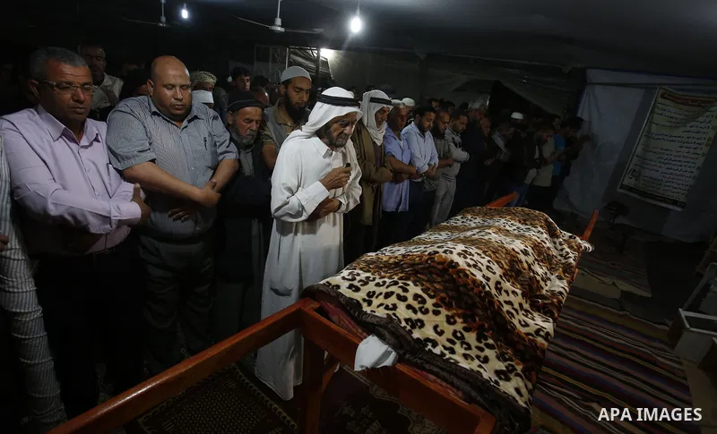 Palestinians perform prayers during a funeral ceremony held for Zine al-Umur, 55, who lost her life after Israeli warplanes bombed around Gaza's southern, in east of the Rafah city, Gaza on May 5, 2016. Photo by Ramadan...