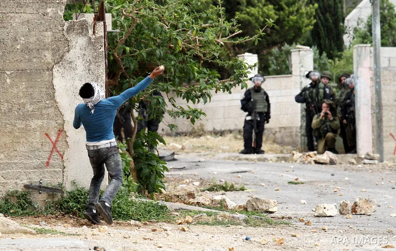 A Palestinian protester hurls stones towards Israeli security forces during clashes following a demonstration against the expropriation of Palestinian land by Israel on May 06, 2016 in the village of Kfar Qaddum, near Na...