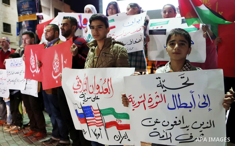 Palestinian hold placards during a protest to show solidarity with Syria in the West Bank of Hebron on May 06, 2016. Photo by Wisam Hashlamoun