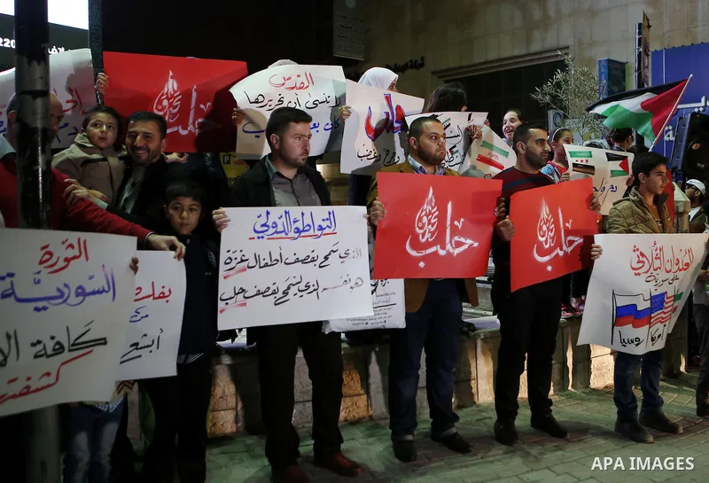 Palestinian hold placards during a protest to show solidarity with Syria in the West Bank of Hebron on May 06, 2016. Photo by Wisam Hashlamoun