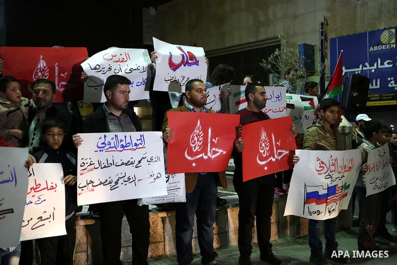 Palestinian hold placards during a protest to show solidarity with Syria in the West Bank of Hebron on May 06, 2016. Photo by Wisam Hashlamoun