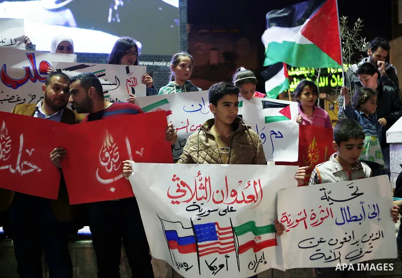 Palestinian hold placards during a protest to show solidarity with Syria in the West Bank of Hebron on May 06, 2016. Photo by Wisam Hashlamoun