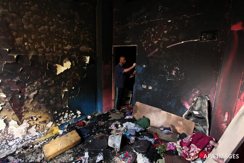 A Palestinian man looks at the charred walls of a house after a candle caused a fire at the al-Hendi family's home at the al-Shati refugee camp in Gaza City on May 7, 2016. Photo by Ashraf Amra
