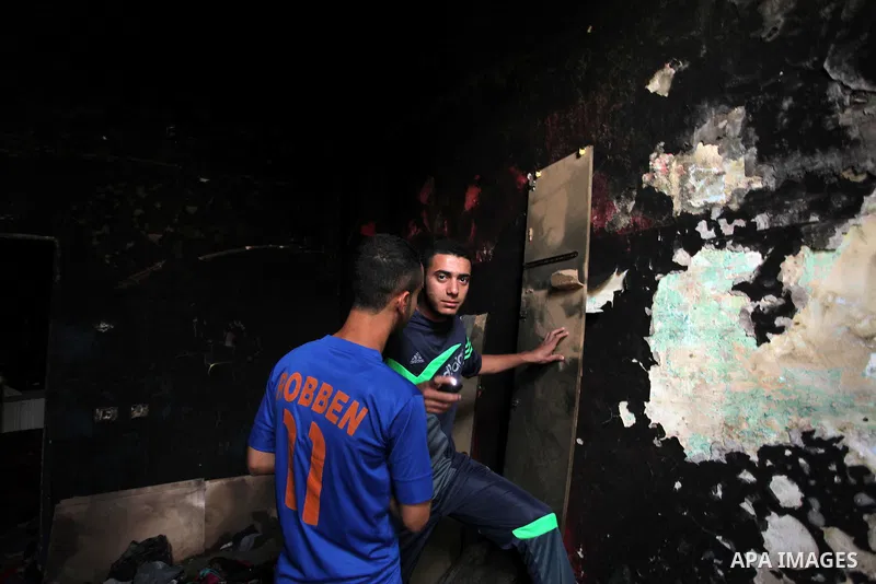 Palestinians look at the charred walls of a house after a candle caused a fire at the al-Hendi family's home at the al-Shati refugee camp in Gaza City on May 7, 2016. Photo by Ashraf Amra