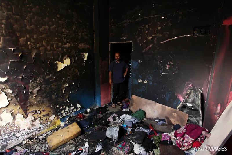 A Palestinian man looks at the charred walls of a house after a candle caused a fire at the al-Hendi family's home at the al-Shati refugee camp in Gaza City on May 7, 2016. Photo by Ashraf Amra